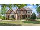 Inviting two-story home with a brick and stone facade, lush landscaping, and a well-manicured lawn at 2400 Gants Hill Pl, Cumming, GA 30041