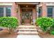 Charming front entryway with brick facade, stone steps, and decorative plants at 2400 Gants Hill Pl, Cumming, GA 30041