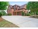 Brick home featuring an attached two-car garage and beautifully landscaped front yard at 2400 Gants Hill Pl, Cumming, GA 30041