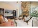 Cozy living room featuring a stone fireplace, ceiling fan and comfortable seating at 2400 Gants Hill Pl, Cumming, GA 30041
