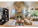 Cozy living room featuring a floor to ceiling stone fireplace, plush seating, and tons of natural light at 2400 Gants Hill Pl, Cumming, GA 30041