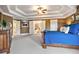 The spacious main bedroom has an oversized bed, carpet flooring, and easy access to the main bathroom at 2400 Gants Hill Pl, Cumming, GA 30041