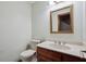 Half bath with decorative wallpaper, a wood vanity with a white sink, and a gold-framed mirror at 4211 Burnt Hickory Nw Rd, Marietta, GA 30064