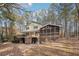 Back of the house with a large porch and lattice detail overlooks the wooded backyard at 4211 Burnt Hickory Nw Rd, Marietta, GA 30064