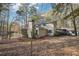 Rear exterior of tan home with a screened porch and lakeside view among bare trees at 4211 Burnt Hickory Nw Rd, Marietta, GA 30064