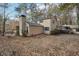 Rear exterior view of tan home with a screened porch and lake view in a wooded area at 4211 Burnt Hickory Nw Rd, Marietta, GA 30064