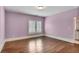 Large bedroom features hardwood floors, light purple walls, and natural lighting from the window at 4884 Kentwood Dr, Marietta, GA 30068
