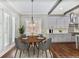 Bright dining area with a modern chandelier, a round wooden table, and open access to the kitchen at 4884 Kentwood Dr, Marietta, GA 30068