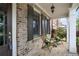 Inviting front porch with brick accents, stylish seating, and a charming outdoor lighting fixture at 4884 Kentwood Dr, Marietta, GA 30068