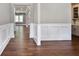 Open hallway featuring hardwood floors, wainscoting, and neutral paint colors to create an inviting atmosphere at 4884 Kentwood Dr, Marietta, GA 30068
