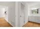 Hallway leading to bathroom with wood-look floors and white cabinets and trim at 228 Smokerise Se Cir, Marietta, GA 30067