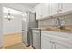 Kitchen with stainless steel refrigerator, white cabinets, stone countertops, and dining room view at 228 Smokerise Se Cir, Marietta, GA 30067