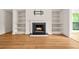 Cozy living room featuring a fireplace with built-in shelves and wood flooring at 228 Smokerise Se Cir, Marietta, GA 30067