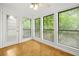 Bright sunroom featuring wood-look floors, a ceiling fan, and expansive windows offering verdant outdoor views at 228 Smokerise Se Cir, Marietta, GA 30067