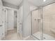 Bright bathroom featuring a modern glass door shower, tiled walls and floors, and open doorway to the walk-in closet at 3001 Greyton Dr, Buford, GA 30519