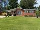 Charming single-story brick home with a well-maintained lawn and mature trees in a quiet neighborhood at 2190 Olive Springs Se Rd, Marietta, GA 30060