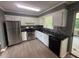 Modern kitchen featuring stainless steel appliances, sleek black countertops, and bright white cabinetry at 2190 Olive Springs Se Rd, Marietta, GA 30060