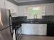 Modern kitchen featuring stainless steel appliances, sleek black countertops, and bright white cabinetry at 2190 Olive Springs Se Rd, Marietta, GA 30060