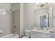 This bathroom features a shower-tub combo with gray tile surround, white vanity, and a large mirror at 3332 Old Concord Se Rd, Smyrna, GA 30082