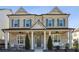 Inviting two-story brick home featuring a covered front porch, white columns, symmetrical design, and blue shutters at 3332 Old Concord Se Rd, Smyrna, GA 30082