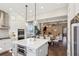 This open-concept kitchen boasts quartz countertops, stainless steel appliances and stylish pendant lighting above island at 3332 Old Concord Se Rd, Smyrna, GA 30082