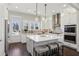 This stunning kitchen features white cabinets, large island with seating, stainless appliances, and hardwood floors at 3332 Old Concord Se Rd, Smyrna, GA 30082