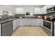 Modern kitchen with stainless steel appliances, herringbone tile floor and gray cabinets at 4699 Price St, Forest Park, GA 30297