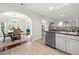Well-lit kitchen features stainless steel appliances, decorative backsplash, and arched entry to the dining room at 4699 Price St, Forest Park, GA 30297