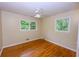 Bright bedroom with hardwood floors, white trim and two windows overlooking lush greenery at 87 Valley Rd, Lawrenceville, GA 30044