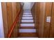 Stairway to the upper level boasts white risers, wood treads, wood handrail, and wood paneled walls at 87 Valley Rd, Lawrenceville, GA 30044