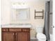 A clean bathroom featuring a granite countertop, white patterned framed mirror, and a modern toilet at 275 13Th Ne St # 409, Atlanta, GA 30309
