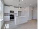 Bright kitchen features white cabinetry, stainless steel appliances, and a center island with pendant lighting at 5 Camellia Dr, Fairburn, GA 30213