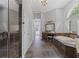 The long bathroom showcases a tiled shower, bathtub, and vanity with great lighting and dual mirrors at 1206 Kincaid Rd, Marietta, GA 30066