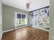 Charming bedroom with hardwood floors, a chandelier, and a unique accent wall with floral and skull wallpaper at 1206 Kincaid Rd, Marietta, GA 30066