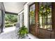 Inviting front porch with brick floor, black columns and a wooden front door adorned with a wreath at 1206 Kincaid Rd, Marietta, GA 30066