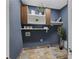 This laundry room features blue walls, slate tile floors, and brown cabinets with storage shelves and decor at 1206 Kincaid Rd, Marietta, GA 30066