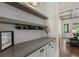 A home wet bar features a gray counter, wine rack, storage cabinets and floating shelves for glassware at 3024 Malbec Vly, Acworth, GA 30101