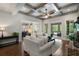 Open living room with coffered ceiling, brick fireplace, and access to an outdoor screened porch at 3024 Malbec Vly, Acworth, GA 30101