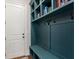 Stylish mudroom with teal built-in shelving, seating, and hooks for organization and storage at 3024 Malbec Vly, Acworth, GA 30101