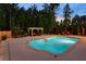 Evening shot of a backyard pool surrounded by lush greenery, pergola, and manicured landscape at 3024 Malbec Vly, Acworth, GA 30101