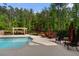 Backyard featuring a sparkling pool, an outdoor lounge under a pergola, and lush landscaping at 3024 Malbec Vly, Acworth, GA 30101
