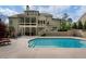 Private backyard featuring a sparkling pool, patio seating, and mature trees, perfect for outdoor living and entertaining at 3024 Malbec Vly, Acworth, GA 30101
