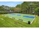 An aerial view of a basketball court surrounded by green grass and tall trees at 580 Grimsby Ct, Suwanee, GA 30024