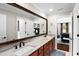 Bathroom with a double vanity, warm cherry cabinets, and a large framed mirror at 580 Grimsby Ct, Suwanee, GA 30024