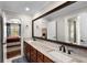 Bathroom with a double vanity, light marble countertops, and a large framed mirror at 580 Grimsby Ct, Suwanee, GA 30024