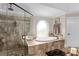 Elegant bathroom with a soaking tub, glass shower, and decorative tile accents at 580 Grimsby Ct, Suwanee, GA 30024