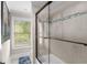 Bathroom with a glass shower door, light beige tiling, and natural light from the window at 580 Grimsby Ct, Suwanee, GA 30024