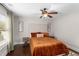 Bedroom featuring a tufted headboard, warm brown bedding, and dark hardwood floors at 580 Grimsby Ct, Suwanee, GA 30024