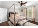 Bright bedroom with a four-poster bed, neutral curtains, and hardwood flooring at 580 Grimsby Ct, Suwanee, GA 30024