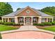 Community building with brick facade, white columns, covered entrance, and manicured landscaping at 580 Grimsby Ct, Suwanee, GA 30024